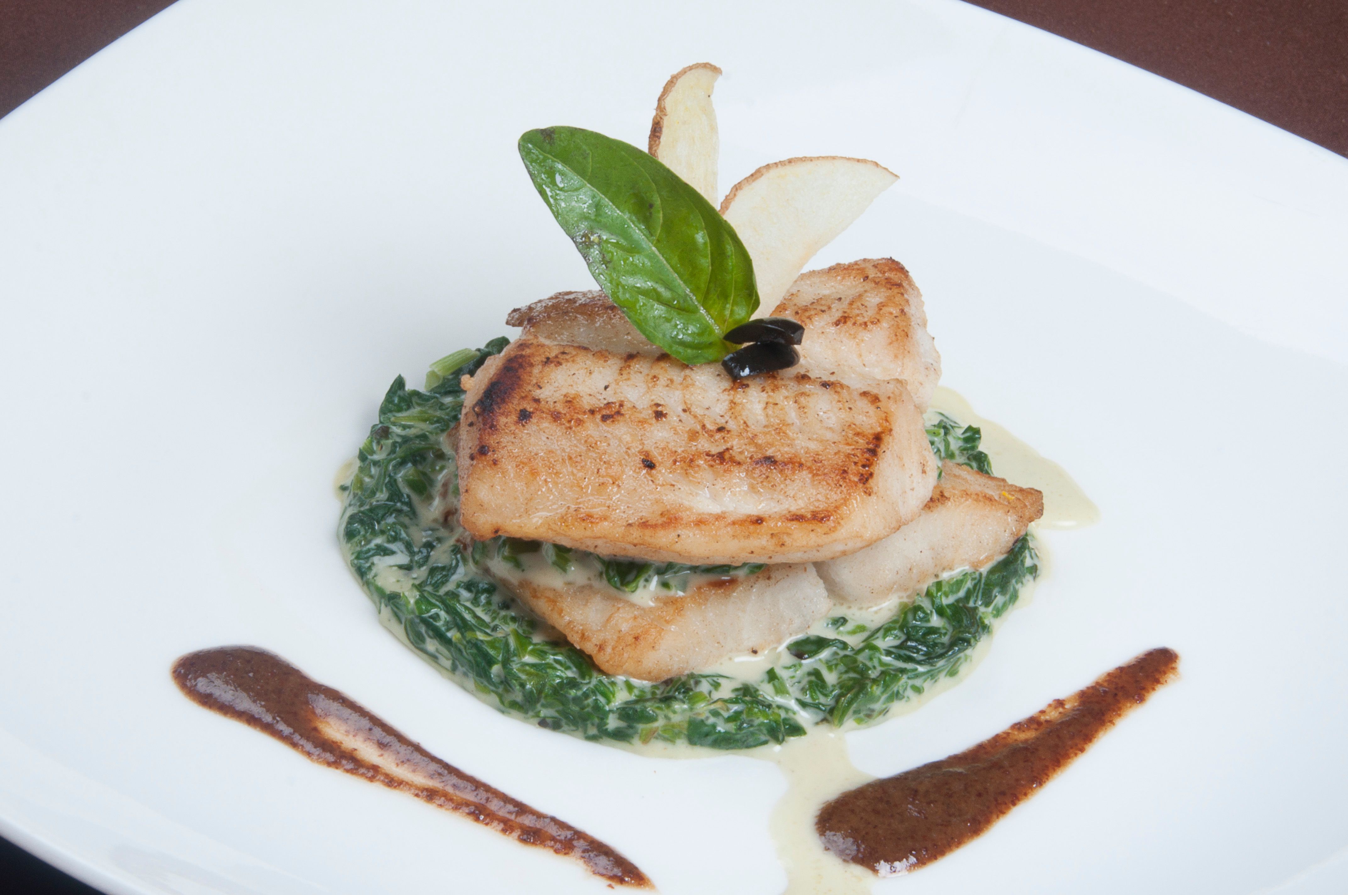Hake fillets with a creamy spinach sauce